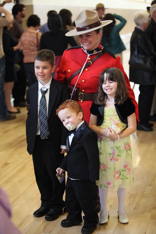 La gendarme Mitchell vêtue de son uniforme de la GRC se tient debout avec ses trois enfants.
