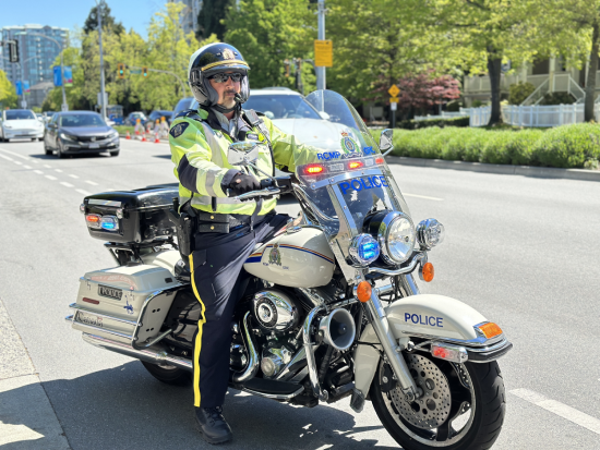 le caporal Peter Somerville du Détachement de la GRC de Richmond sur sa moto, immobile, sous un ciel radieux et ensoleillé.