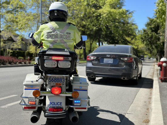 Corporal Peter Somerville conducting a traffic stop on his motorcycle at the side of the road