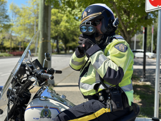 Corporal Peter Somerville on his motorcycle conducting a speed check facing the camera