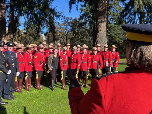 RCMP officer standing in front of a group of RCMP officers outside